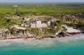 Aerial view of Tulum ruins perched on the clifftop above the sea