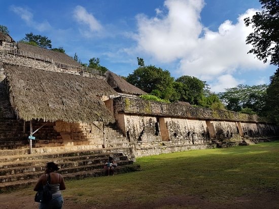 Long palace structure at Ek Balam with thatched protective roof under a blue sky