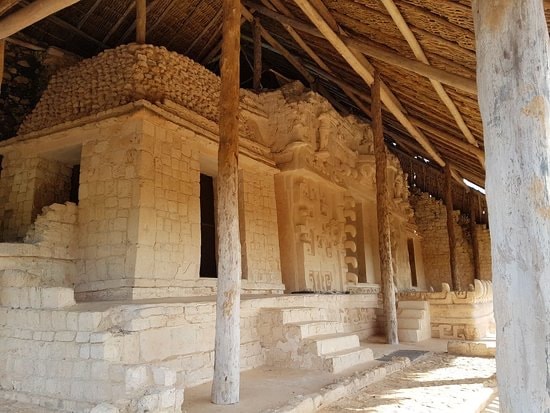 Intricate stucco carvings on the Ek Balam tomb facade with jaguar and deity figures