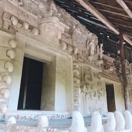 Detailed stucco relief carvings on the Ek Balam pyramid facade with twin windows