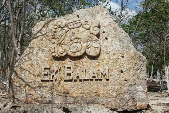Carved stone Ek Balam entrance monument with Maya glyph in the jungle