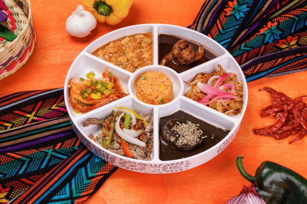Traditional Mexican dinner platter with mole, rice, cochinita pibil and other regional dishes at Xoximilco